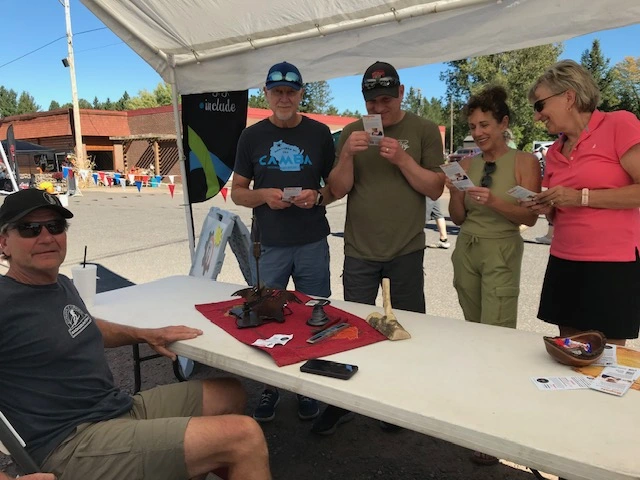 Group of people around a table during an outdoor event.